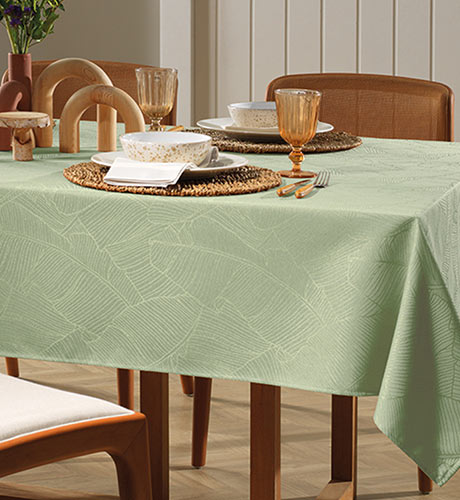 mesa armada con vajillas y mantel verde claro